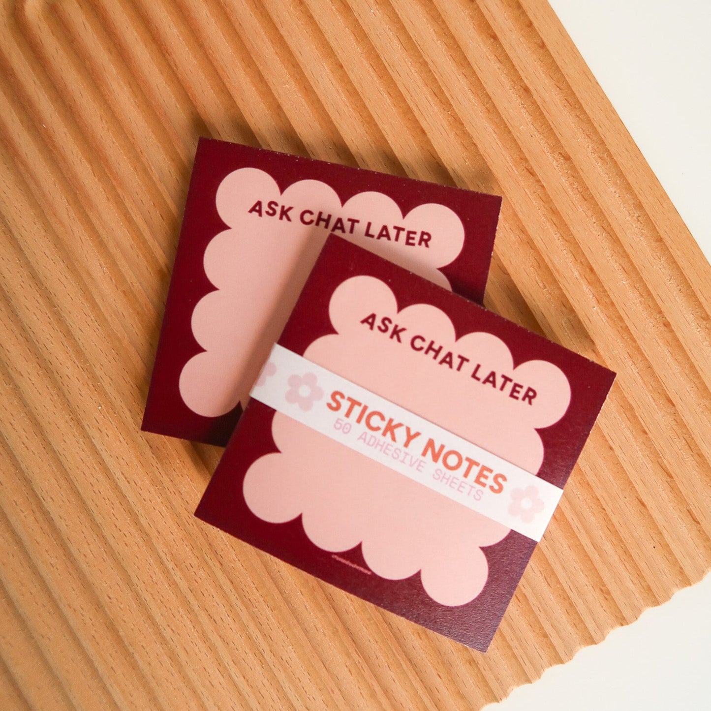 Two packs of 'Ask Chat Later' sticky notes on a wooden surface