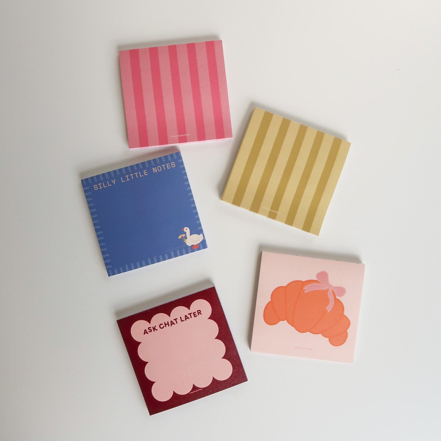 Five small square cards with different designs on a white background