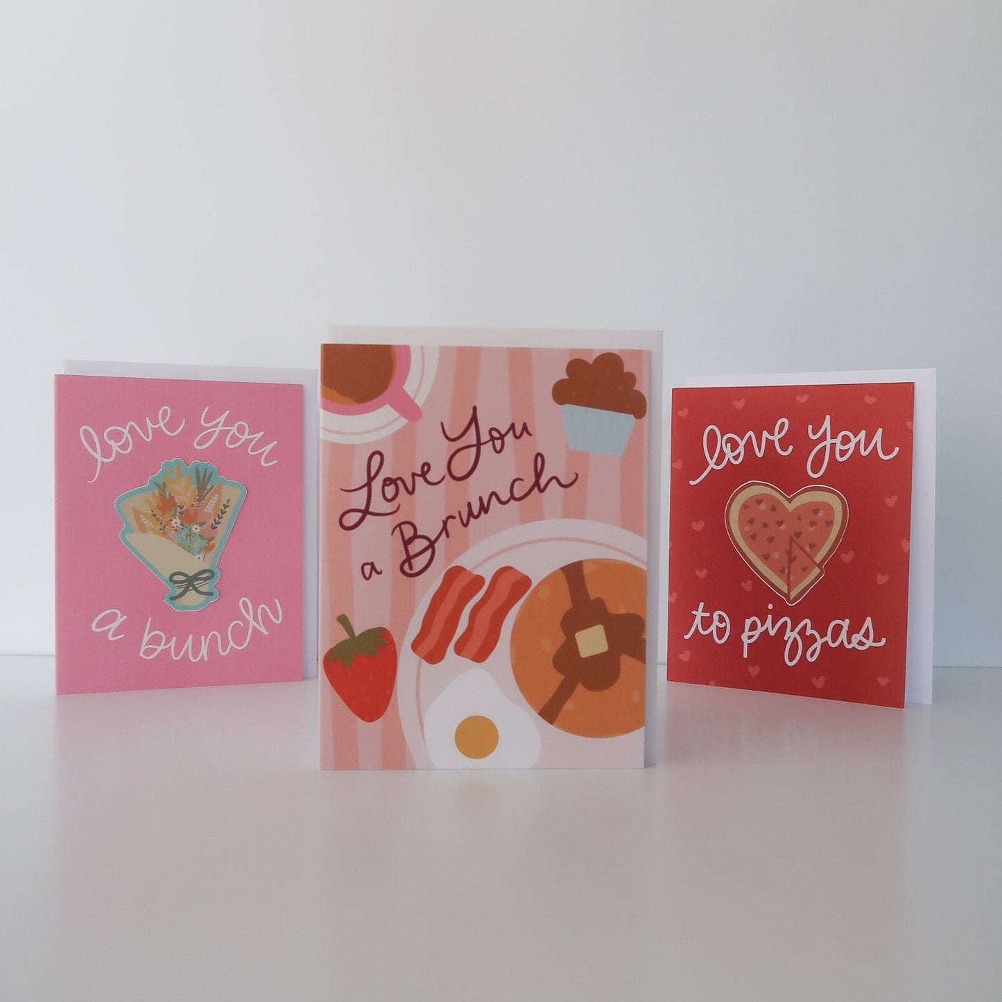 Three greeting cards with different designs on a white surface.