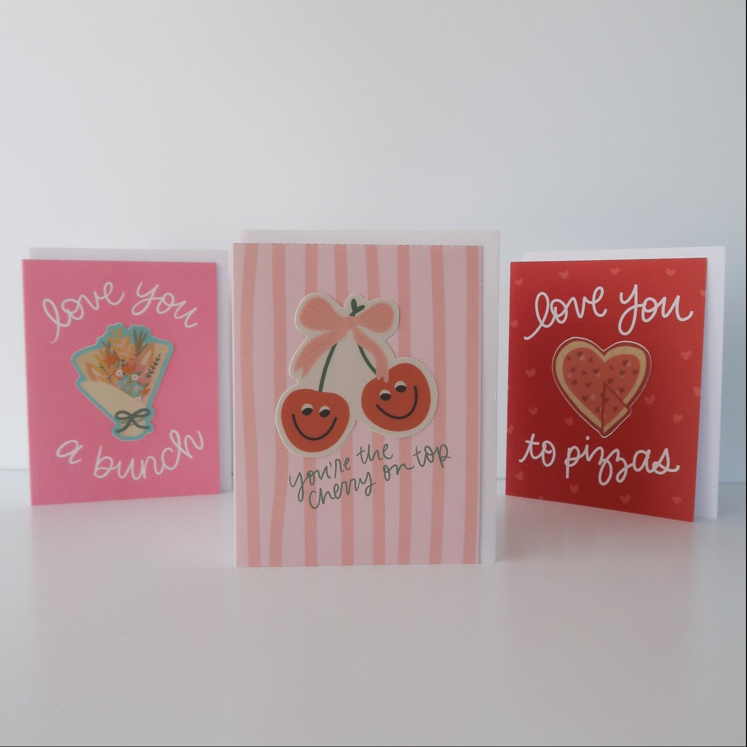 Three small greeting cards with different designs on a white background